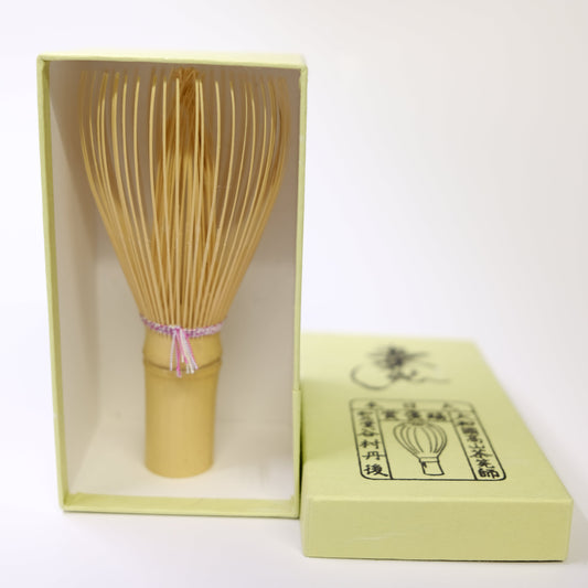 Bamboo whisk in a yellow box on a white background